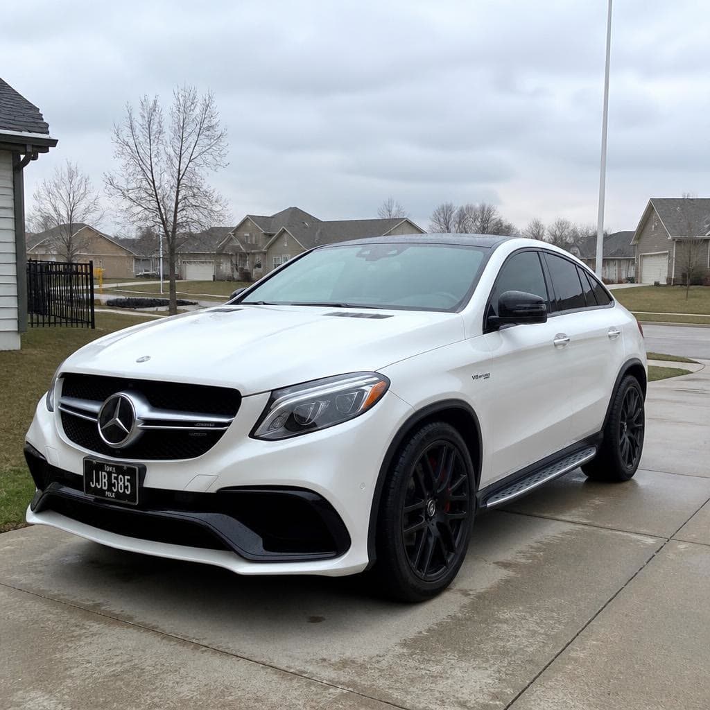 A white Mercedes-AMG coupe in a clean driveway.