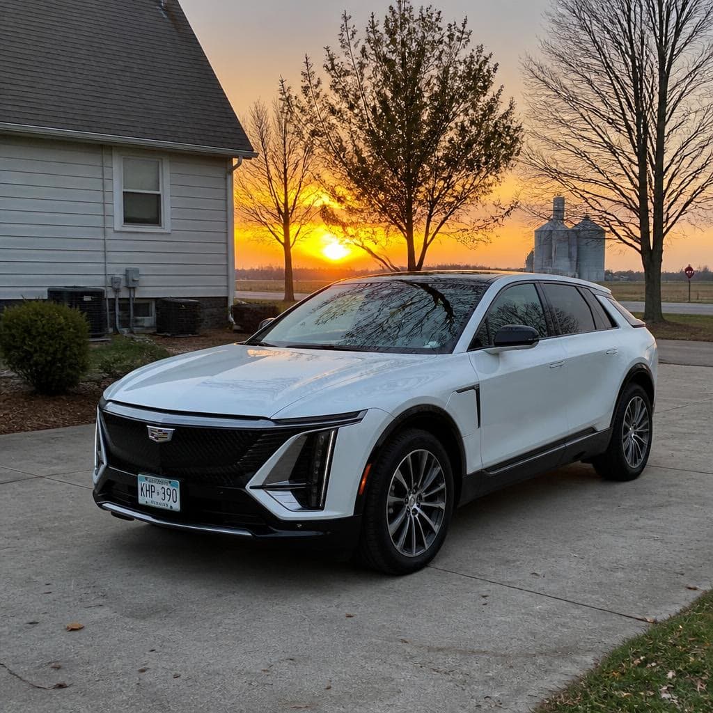 A white Cadillac in a driveway at sunset.