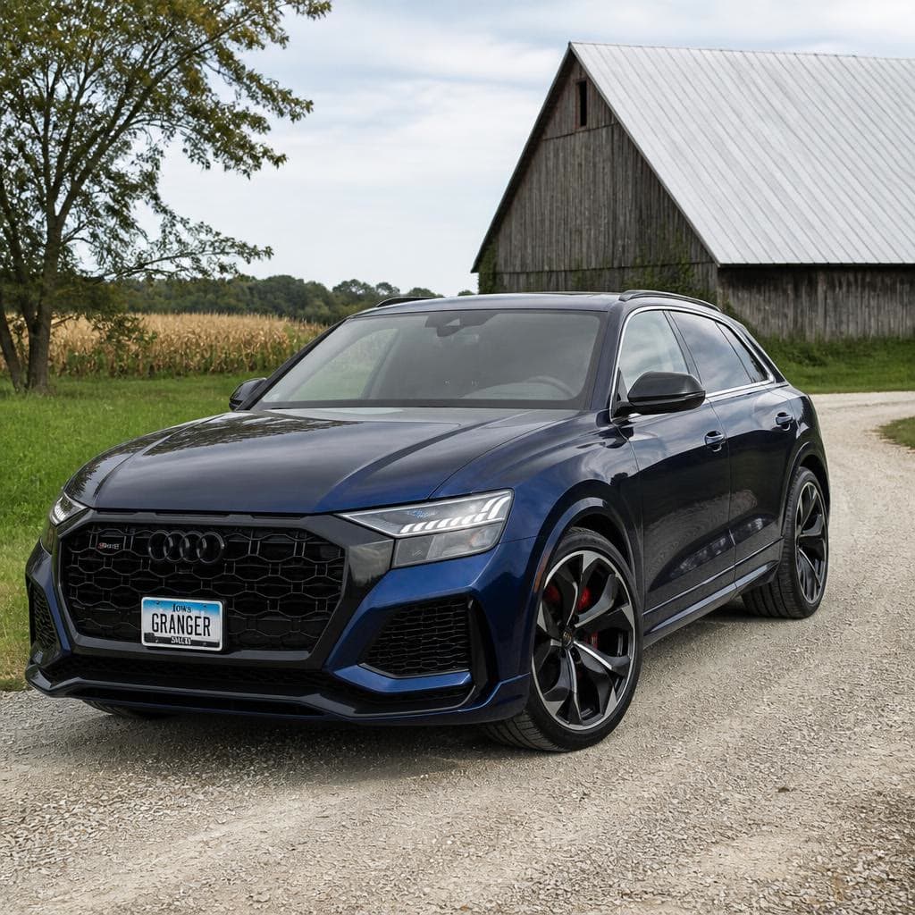 A dark blue Audi SUV on a gravel driveway.